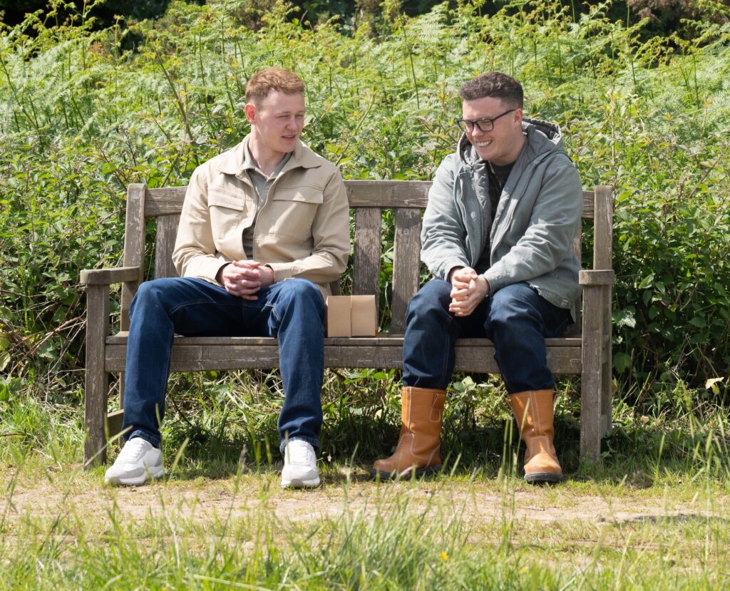 Vinny sits on a bench with his new friend Mike in Emmerdale