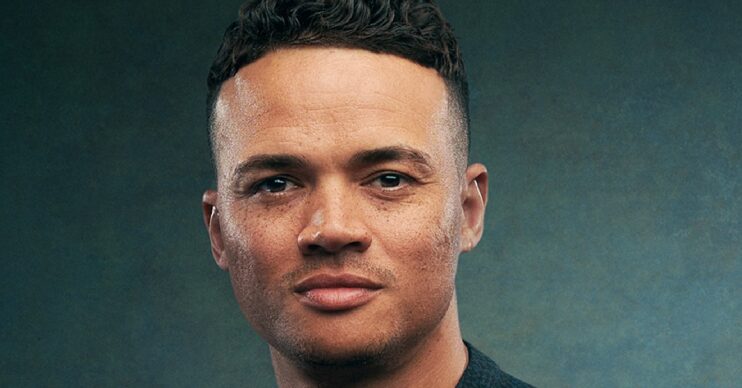 Jermaine Jenas eyes to camera against a green background