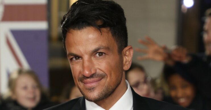 Peter Andre smiling at the camera wearing a dark suit